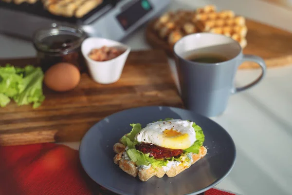 Яйця Бенедикт з хлібом і помідорами на тарілці з бутербродом — стокове фото