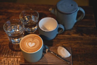 İki bardak kahve ve bir bardak su rustik ahşap masa üzerinde. Yakın çekim