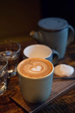 İki bardak kahve ve bir bardak su rustik ahşap masa üzerinde. Yakın çekim