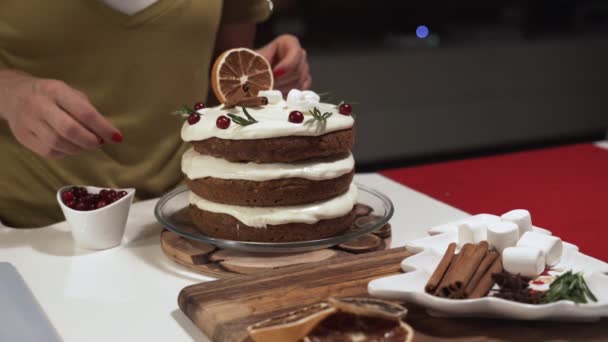 Frau dekoriert selbst gebackenen Kuchen in der Küche — Stockvideo