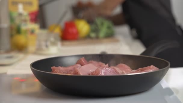 Friggere la carne nella padella sul fornello elettrico. La donna mescola la carne fritta nella padella sulla stufa elettrica — Video Stock