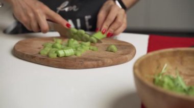 Kadın ev yapımı sebze salatası pişirmek için kereviz kesiyor..