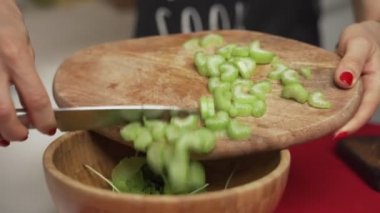 Kadın ev yapımı sebze salatası pişirmek için kereviz kesiyor.