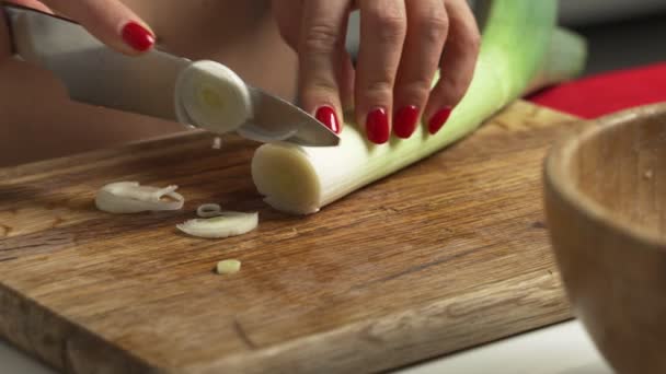Top shot di donna chef tagliare dadi cipollotto, scalogno sul tagliere di legno — Video Stock