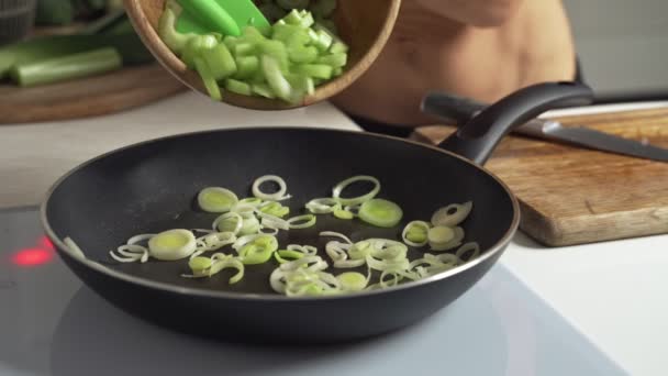 Cebolla verde y apio frito en sartén de hierro fundido . — Vídeos de Stock