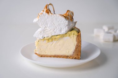 Limon beze cheesecake beyaz arka plan üzerinde beyaz plaka üzerinde