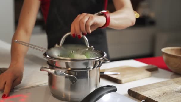 Groene broccoli wordt gekookt in stoom in een RVS steamer. — Stockvideo