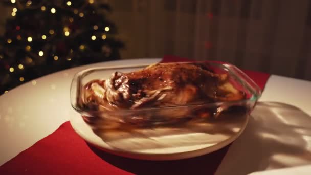 Mujeres manos vertiendo miel y mostaza en ganso asado. Ganso asado con manzanas y naranjas en horno. Árbol de Navidad en el fondo — Vídeos de Stock