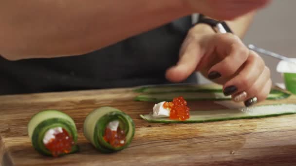 Mani femminili che fanno rotolo di spuntino di formaggio di caviale e cetriolo — Video Stock