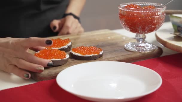 Frauenhände backen Sandwiches mit rotem Kaviar — Stockvideo