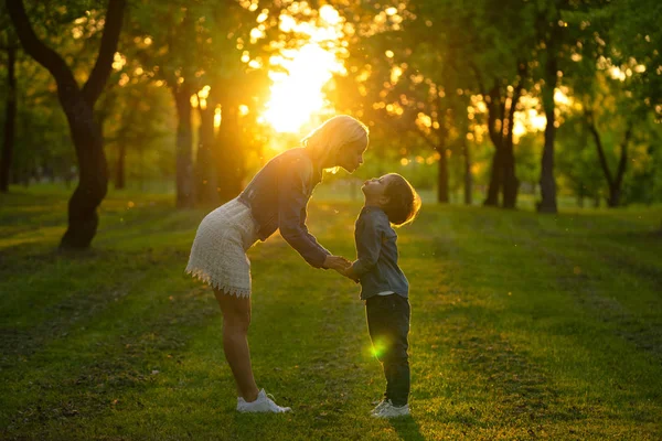 Mãe e filho pequeno no parque ou floresta, ao ar livre. Abraçando e se divertindo juntos — Fotografia de Stock