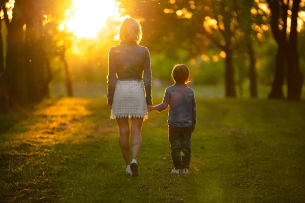 Madre e hijo pequeño en el parque o el bosque, al aire libre. Abrazar y divertirse juntos —  Fotos de Stock