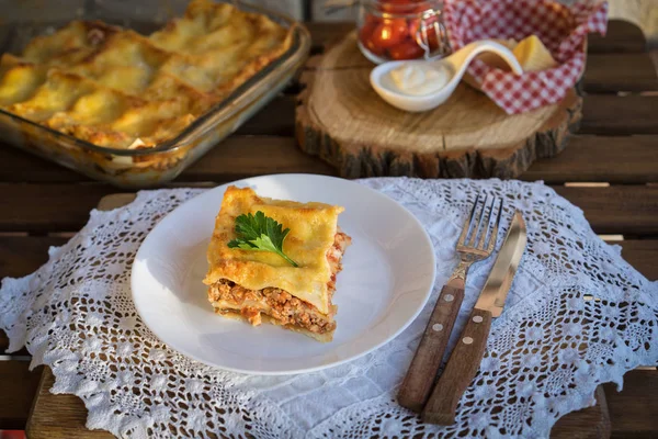 Klassieke hommade lasagne met bolognese saus op houten tafel met kant tafelkleed — Stockfoto