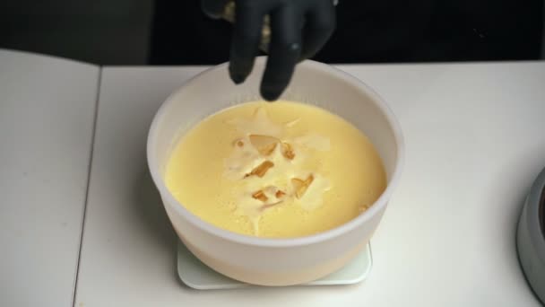 Mujer confitera en uniforme negro preparar crema para pastel de mousse de chocolate. Tarta de mousse de cocina etapa — Vídeos de Stock