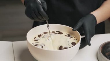 Siyah üniformalı kadın pudra krem çikolata mousse kek için hazırlayın. Sahne pişirme mousse kek