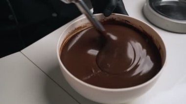 Siyah üniformalı kadın pudra krem çikolata mousse kek için hazırlayın. Sahne pişirme mousse kek