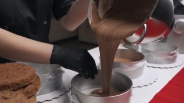 Siyah üniformalı kadın pudra krem çikolata mousse kek için hazırlayın. Sahne pişirme mousse kek