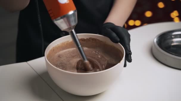 Mujer confitera en uniforme negro preparar crema para pastel de mousse de chocolate. Tarta de mousse de cocina etapa — Vídeos de Stock