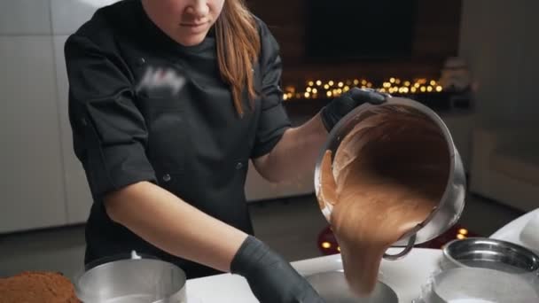 Mujer confitera en uniforme negro preparar crema para pastel de mousse de chocolate. Tarta de mousse de cocina etapa — Vídeos de Stock