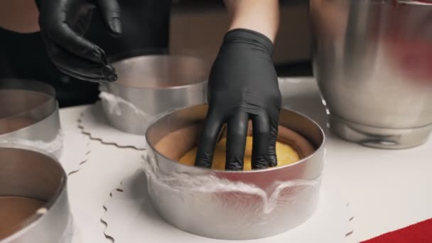 Vrouw banketbakker in zwart uniform bereiden crème voor chocolademousse taart. Fase koken mousse taart — Stockvideo