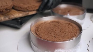 Siyah üniformalı kadın pudra krem çikolata mousse kek için hazırlayın. Sahne pişirme mousse kek