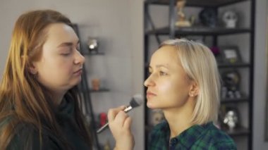 Profesyonel makyaj sanatçısı, iş fırça el closeup - güzellik moda endüstrisi kozmetik sahne arkasında profesyonel makyaj - yan makro görünümü güzel doğal ışık Studio windows ile