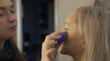 Profesyonel makyaj sanatçısı, iş fırça el closeup - güzellik moda endüstrisi kozmetik sahne arkasında profesyonel makyaj - yan makro görünümü güzel doğal ışık Studio windows ile