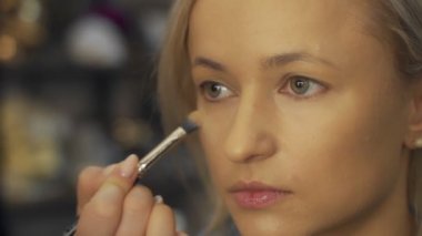 Profesyonel makyaj sanatçısı, iş fırça el closeup - güzellik moda endüstrisi kozmetik sahne arkasında profesyonel makyaj - yan makro görünümü güzel doğal ışık Studio windows ile