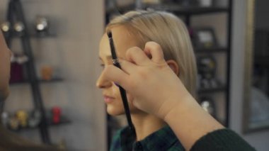Profesyonel makyaj sanatçısı, iş fırça el closeup - güzellik moda endüstrisi kozmetik sahne arkasında profesyonel makyaj - yan makro görünümü güzel doğal ışık Studio windows ile