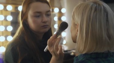 Profesyonel makyaj sanatçısı, iş fırça el closeup - güzellik moda endüstrisi kozmetik sahne arkasında profesyonel makyaj - yan makro görünümü güzel doğal ışık Studio windows ile