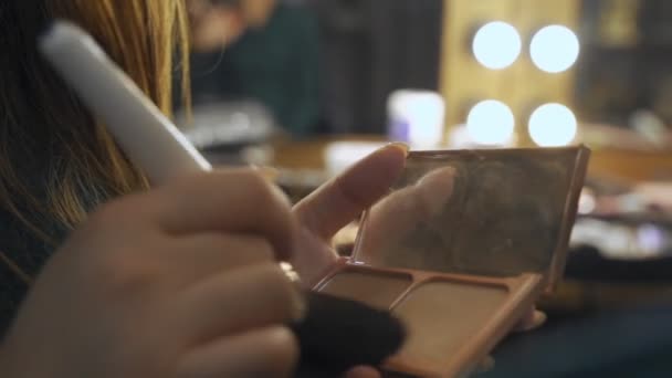 Una paleta con sombras de ojos y un cepillo de maquillaje: cosméticos para mujer. Maquillaje matutino. Cosmética decorativa: una paleta con sombras de ojos, un pincel.Maquillaje de noche.Detalles del trabajo de los artistas de maquillaje . — Vídeo de stock