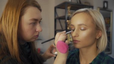 profesyonel makyaj sanatçısı genç modeli için göz makyaj yapma