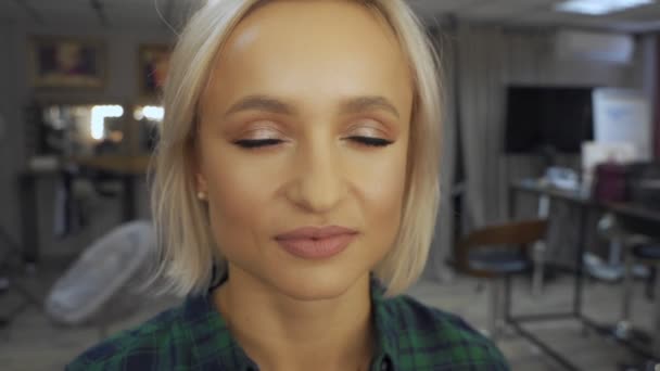 Professional make-up artist at work brush hand closeup - beauty fashion industry cosmetics backstage professional makeup - side view macro beautiful natural lighting in studio with windows — Stock Video