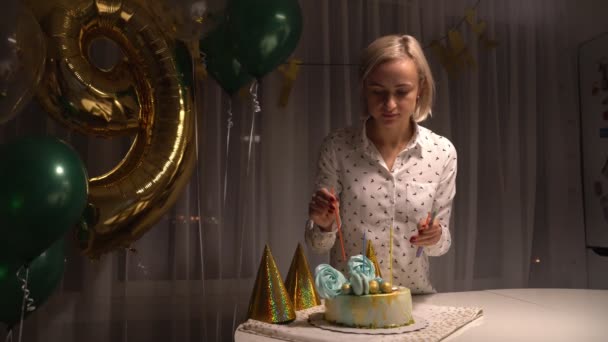 Middle shot of Woman lighting candles on tasty birthday cake. Prepearing for party. — Stockvideo