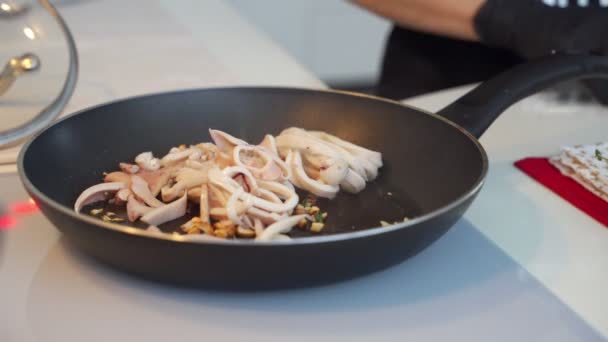 Anillos fritos de calamar con hierbas y cebolla en la sartén . — Vídeos de Stock