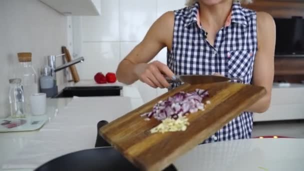 Dans une poêle, faire revenir l'oignon dans l'huile. Clip. Faire revenir les sautés végétariennes. Une saine alimentation. Vue de dessus. Vue du dessus faire revenir les légumes dans un wok . — Video