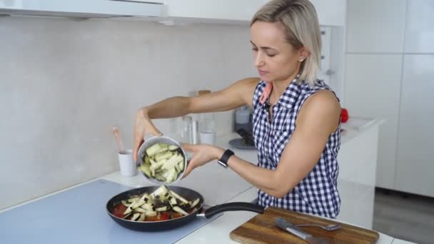 Mujer friendo verduras y ternera con tomates . — Vídeo de stock