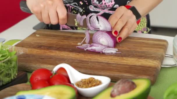 Mãos de mulher com rabanetes de corte de faca de salada. Feche os legumes frescos na mesa da cozinha. Dona de casa cozinhar refeição natural e saudável no tabuleiro de madeira. Vegetais sazonais ingredientes para salada — Vídeo de Stock