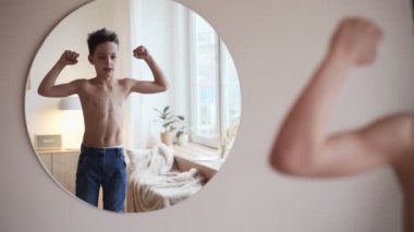 Kendine güvenen çocuk süper kahraman o ayna hayal içinde kasları bakarak