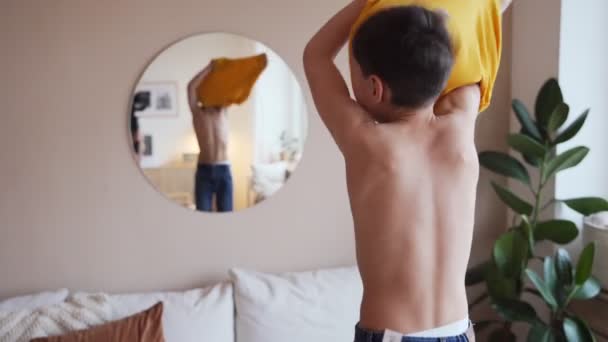 Niño confiado mirando sus músculos en el espejo imaginando que él es súper héroe — Vídeo de stock