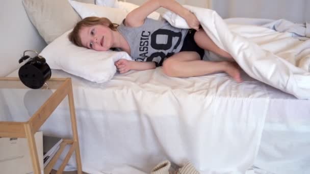 Γλυκό παιδί που κοιμάται με Ξυπνητήρι κοντά το κεφάλι του. — Αρχείο Βίντεο
