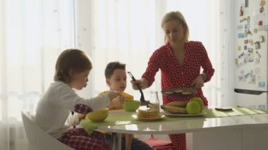 Anne kızartma için iki erkek krep. Çocuklar Kahvaltı