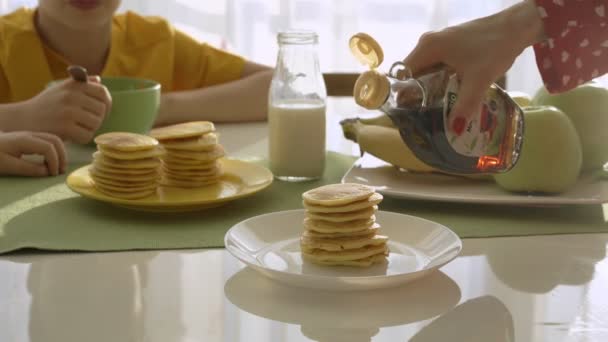 Mamá friendo panqueques para dos chicos. Chicos desayunando — Vídeos de Stock