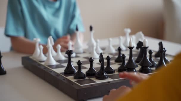 Two boy playing chess in light room. Two brothers playing chess. — Stock Video