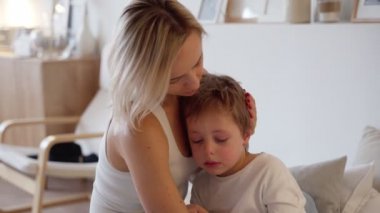 genç anne ağlayan bir çocuk yatak odasında kucak.