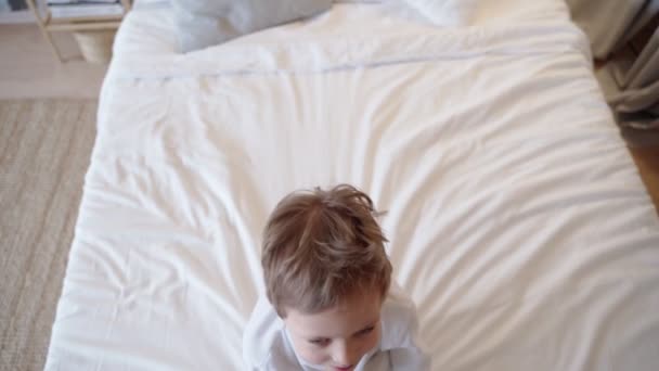 Menino brincando, adormece na cama antes de dormir . — Vídeo de Stock