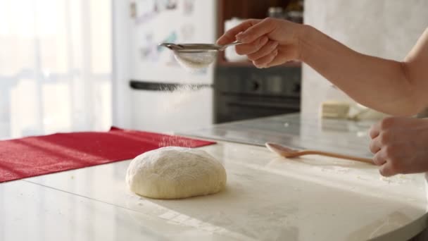 Panadero amasar la masa en harina sobre la mesa. Primer plano de las manos femeninas que trabajan con masa — Vídeo de stock