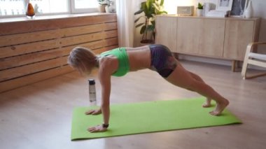 Genç kadın evde egzersiz yapıyor. Beyaz kadın Yoga Mat vücut ağırlığı egzersizleri yapıyor