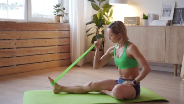 Mujer joven haciendo ejercicio en casa. Mujer caucásica haciendo ejercicios de peso corporal en esterilla de yoga — Vídeos de Stock