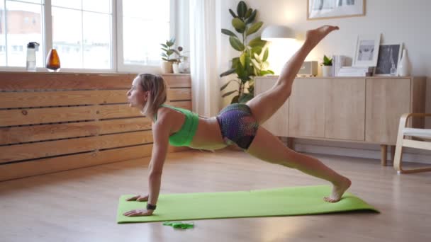 Junge Frau beim Training zu Hause. Kaukasierin macht Körpergewichtsübungen auf Yogamatte — Stockvideo